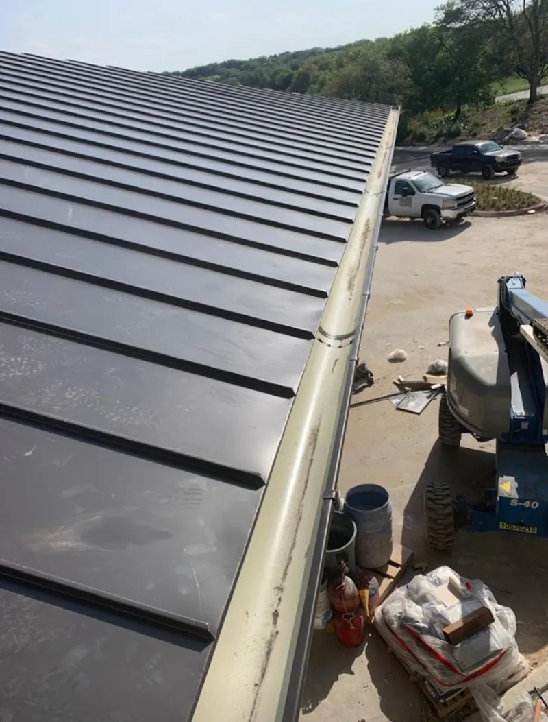 Standing seam panel and gutter detail on a metal roofing jobsite in Socorro